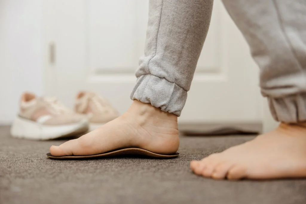 Person standing on a flat foot orthotic.